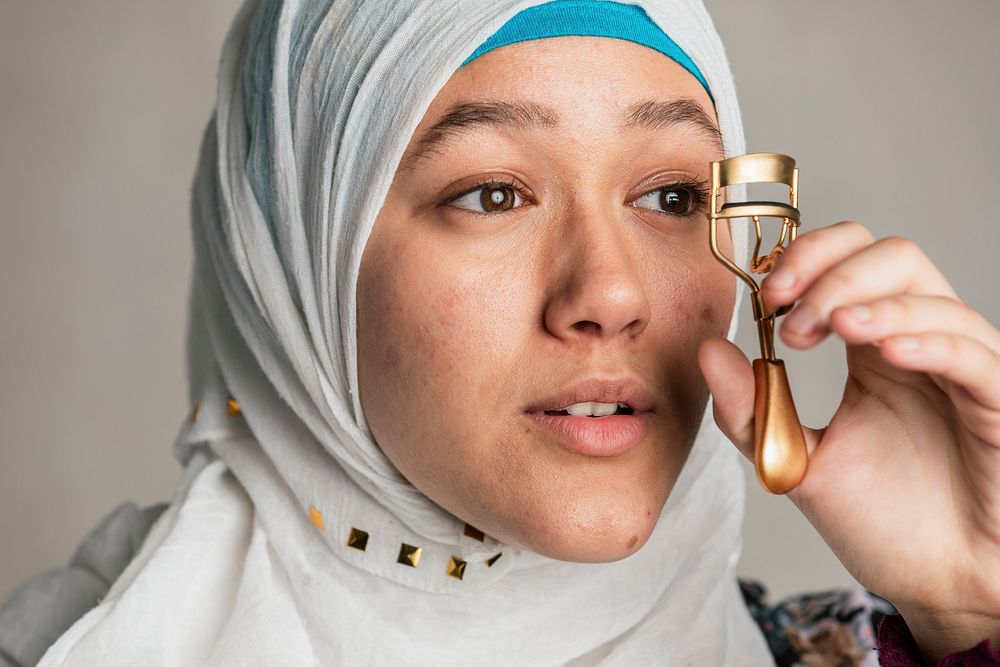 Young Islamic woman curling her eyelashes