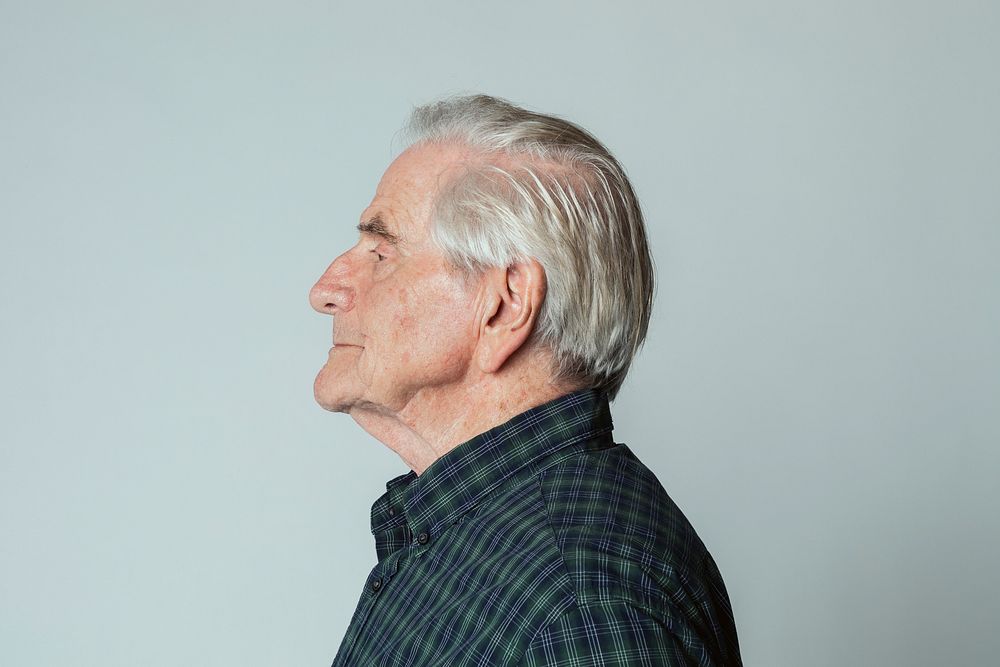 Senior man wearing a tartan shirt in profile shot 