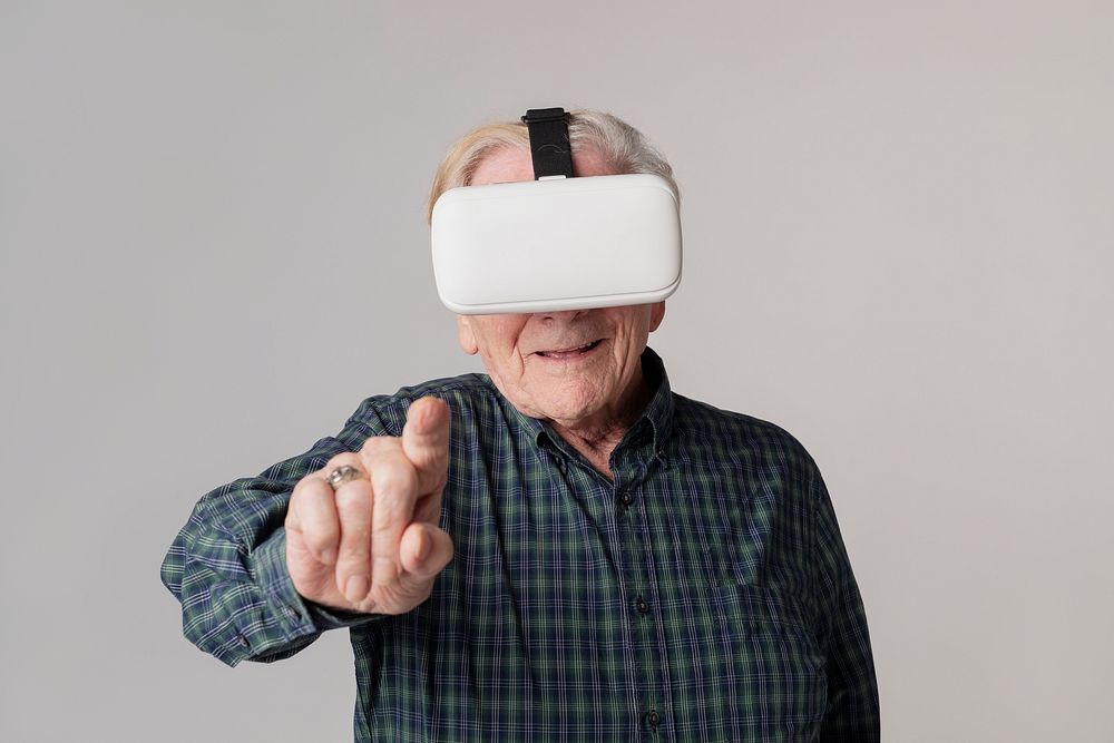 Cheerful senior man wearing virtual reality goggles