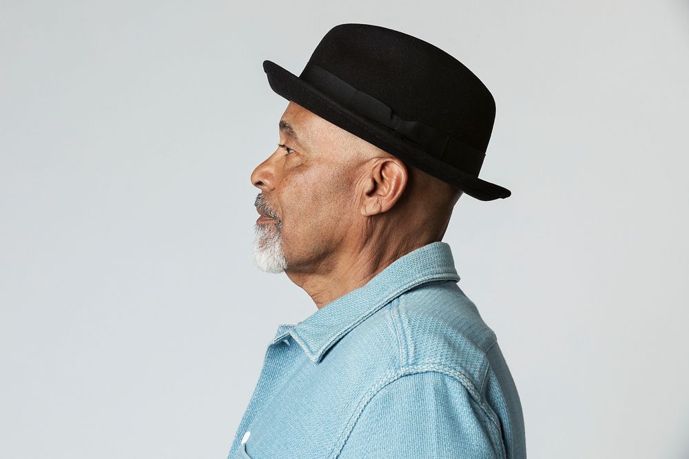 Stylish senior man wearing a black hat in a profile shot 