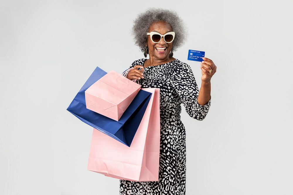 Cheerful senior woman on a shopping spree with a credit card 