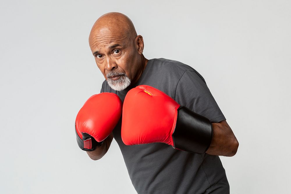 Senior man with red boxing gloves