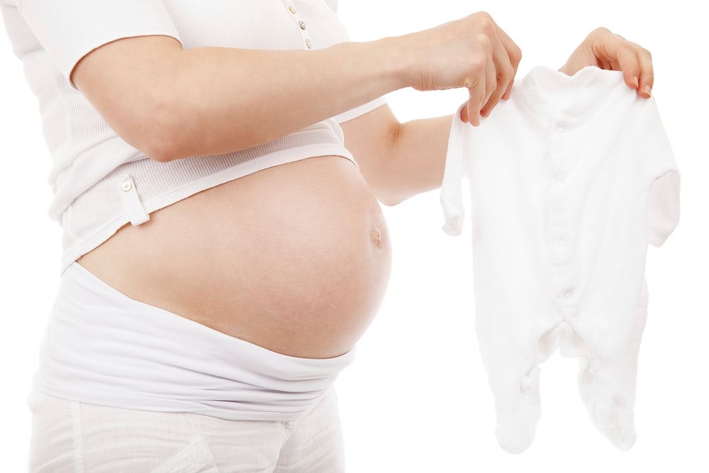 Free pregnant women are picking up baby cloth public domain people CC0 photo.