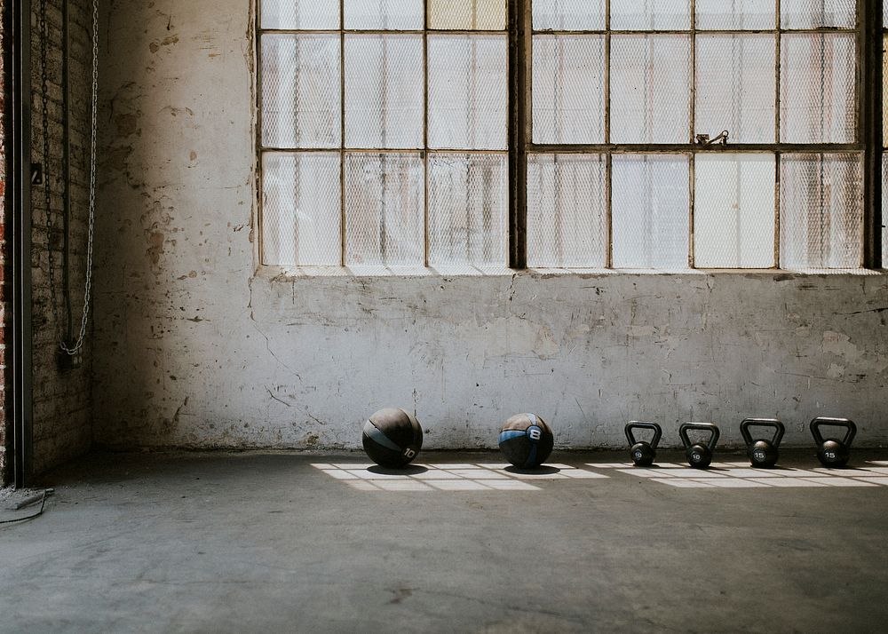 View of fitness equipment by the windows of a gym