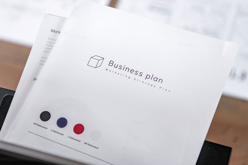 White business plan book on wooden table