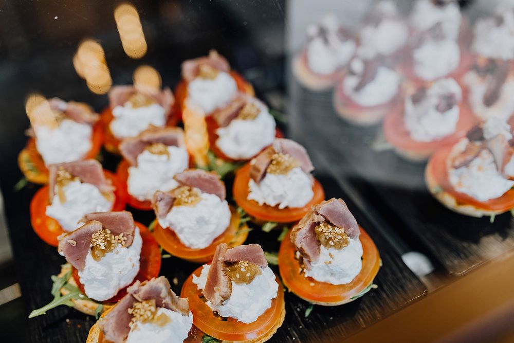 Fresh tomato with cream cheese topped with slices of meat