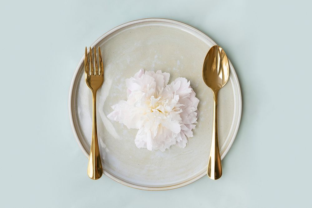 Beautiful paeonia snow board on a plate with golden spoon and fork