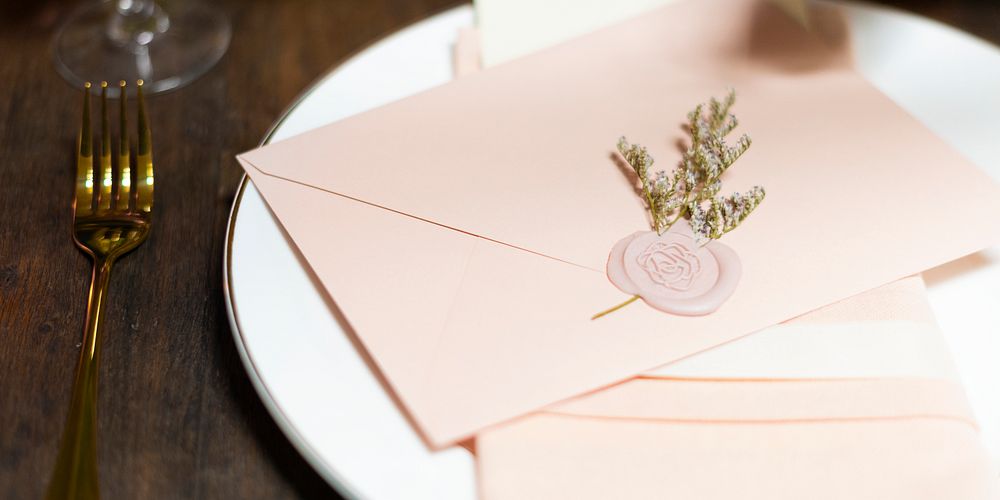 Floral stamped pink envelope on a plate