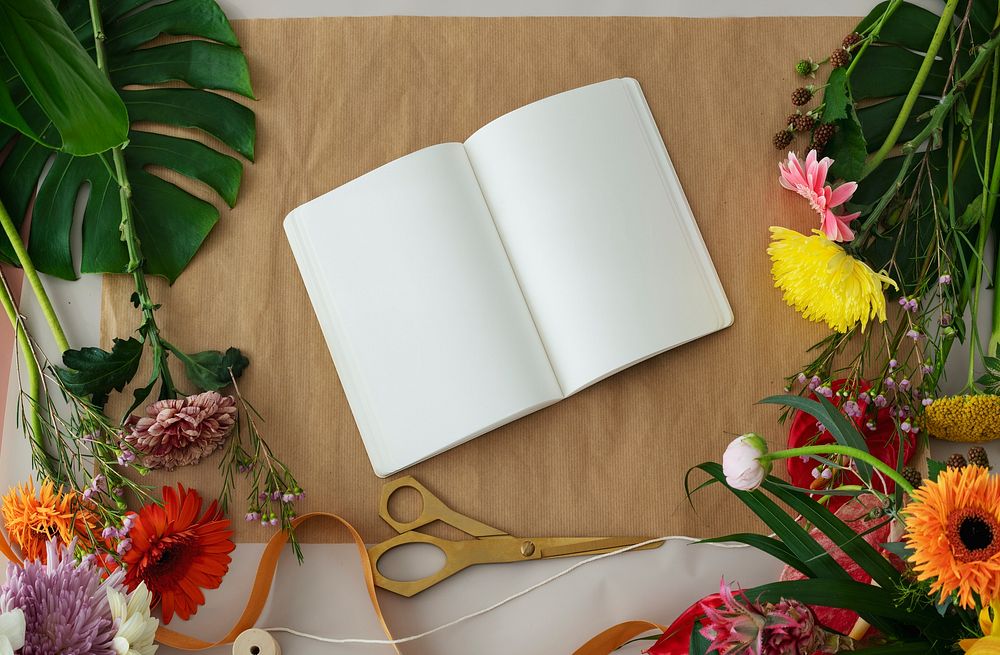 Blank notebook mockup among colorful flowers