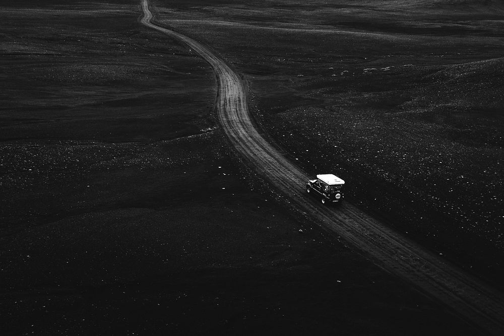 Drone view of a Suzuki Jimny driving on a dirt road