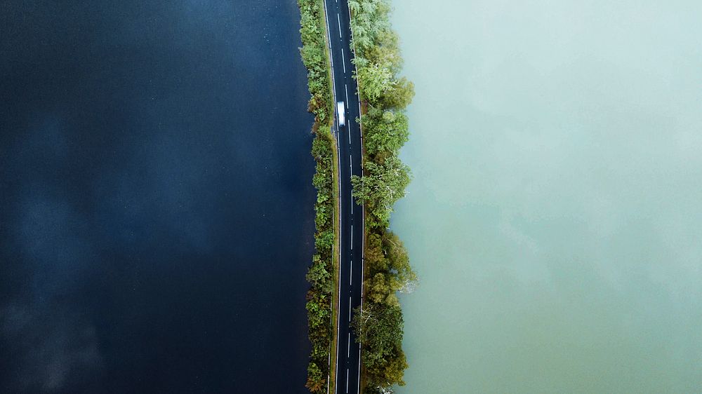Driving along the road on a lake drone shot