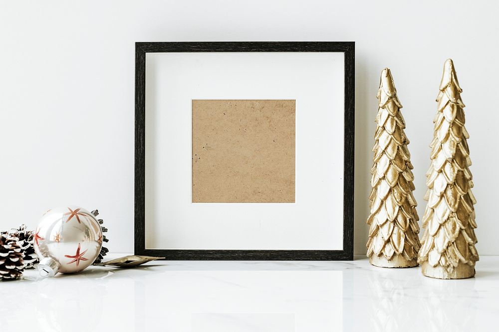 Picture frame on a table with golden Christmas tree