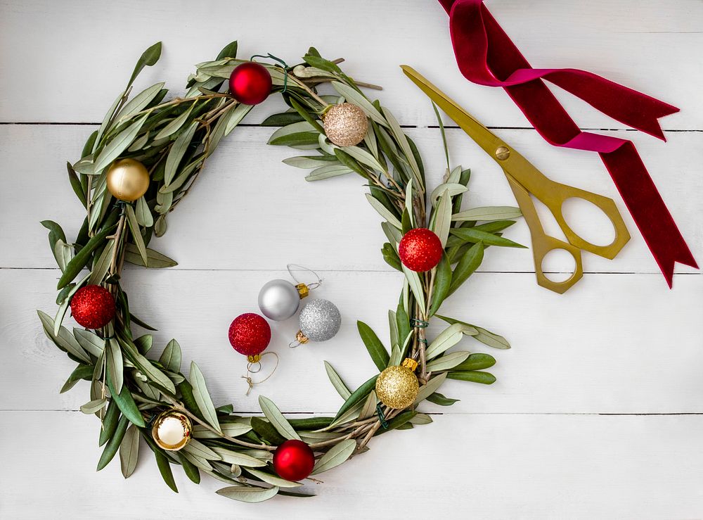 Flat lay of Christmas DIY wreath decoration on a rustic white wood