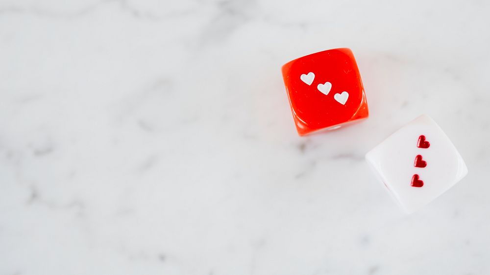 Two heart dices on a white marble background