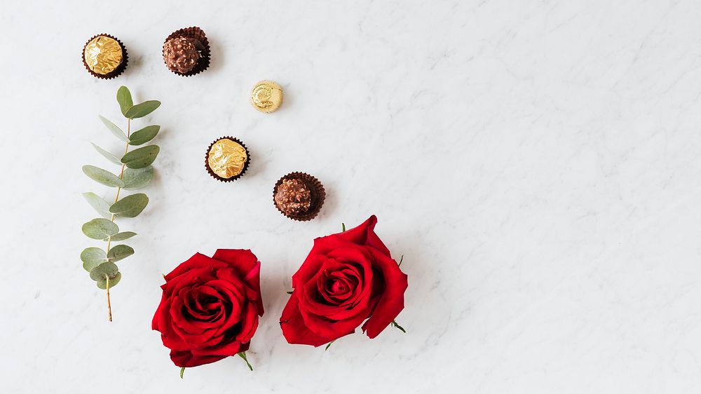 Round nutty chocolates by a red rose wallpaper