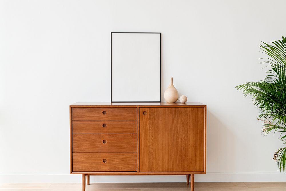 Blank picture frame on a wooden cabinet