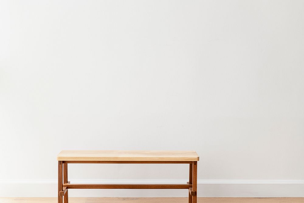Wooden bench by a white wall