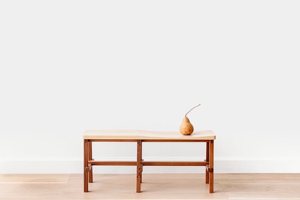 Brown pear on a wooden bench in a white room