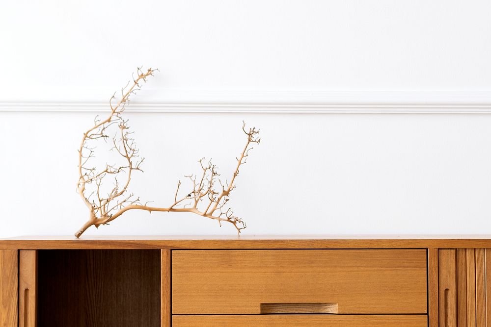 Wooden sideboard table against a white wall 