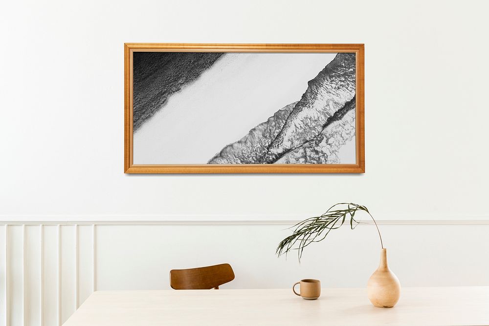 Picture frame mockup hanging on a white wall by the dining table 