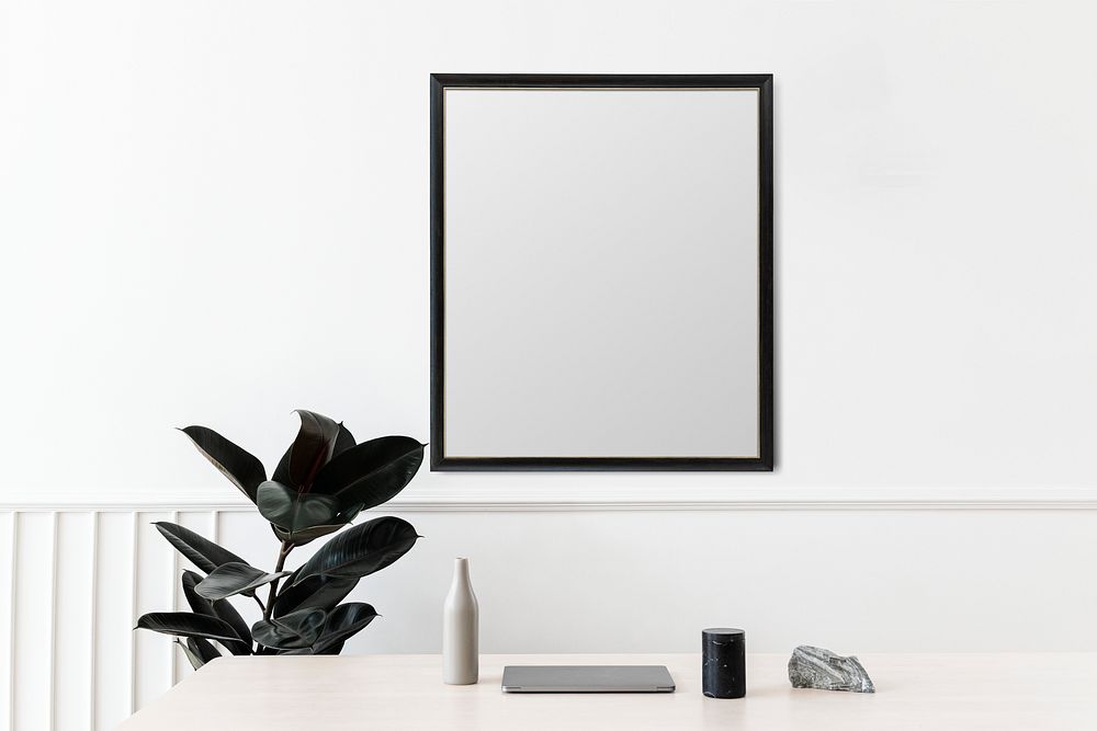 Blank picture frame hanging on a white wall