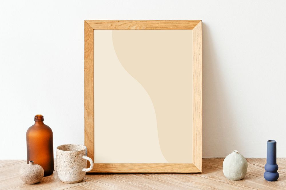 Picture frame mockup on a wooden sideboard table with a ceramic cup