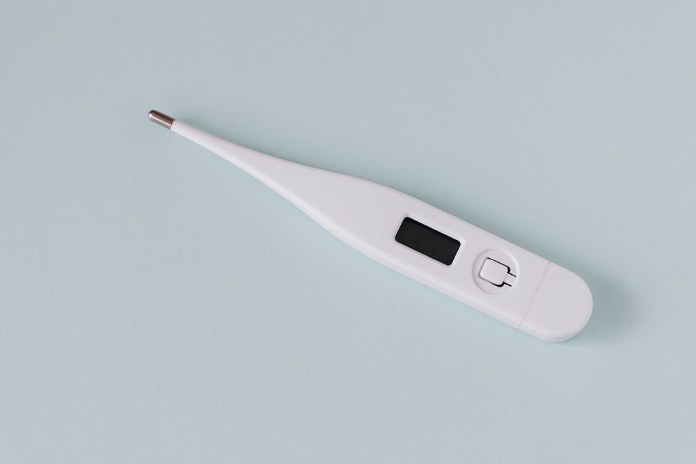 White digital thermometer on a gray background