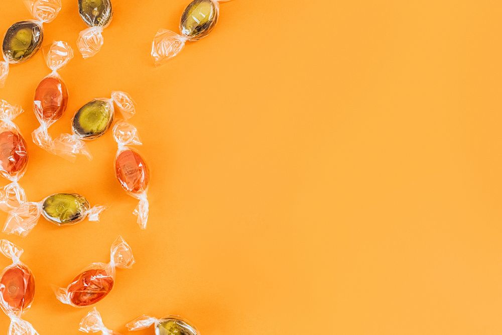 Candy on an orange background with copy space 