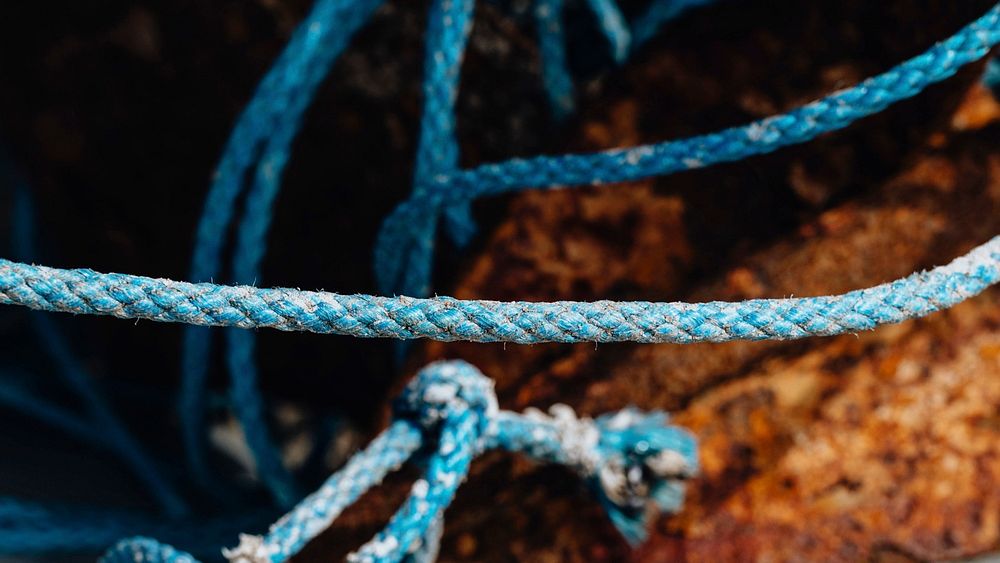 Blue ropes and rusty fishing equipment textured background