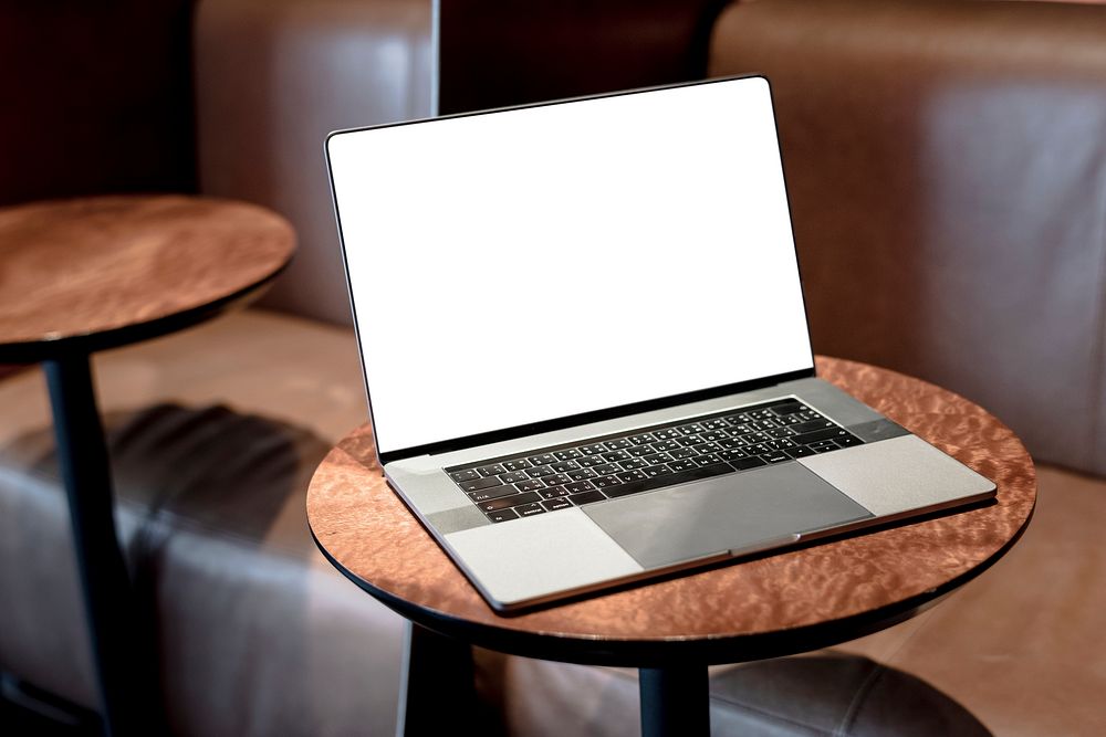 Laptop screen mockup on a table at a coffee shop psd