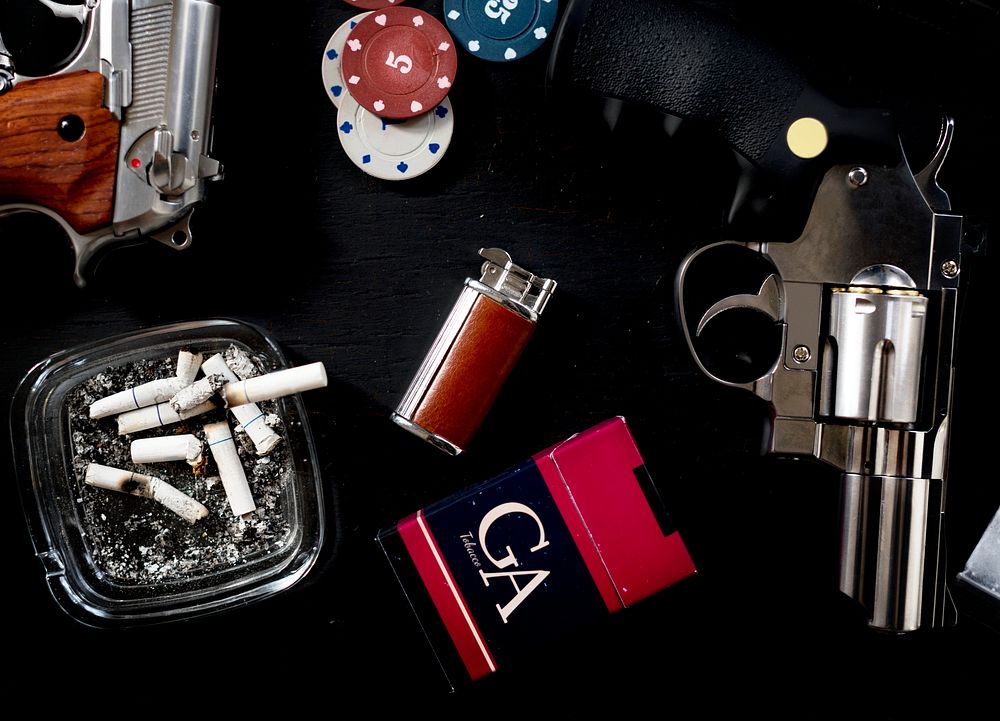 Guns, cigarettes, gambling coins on a table