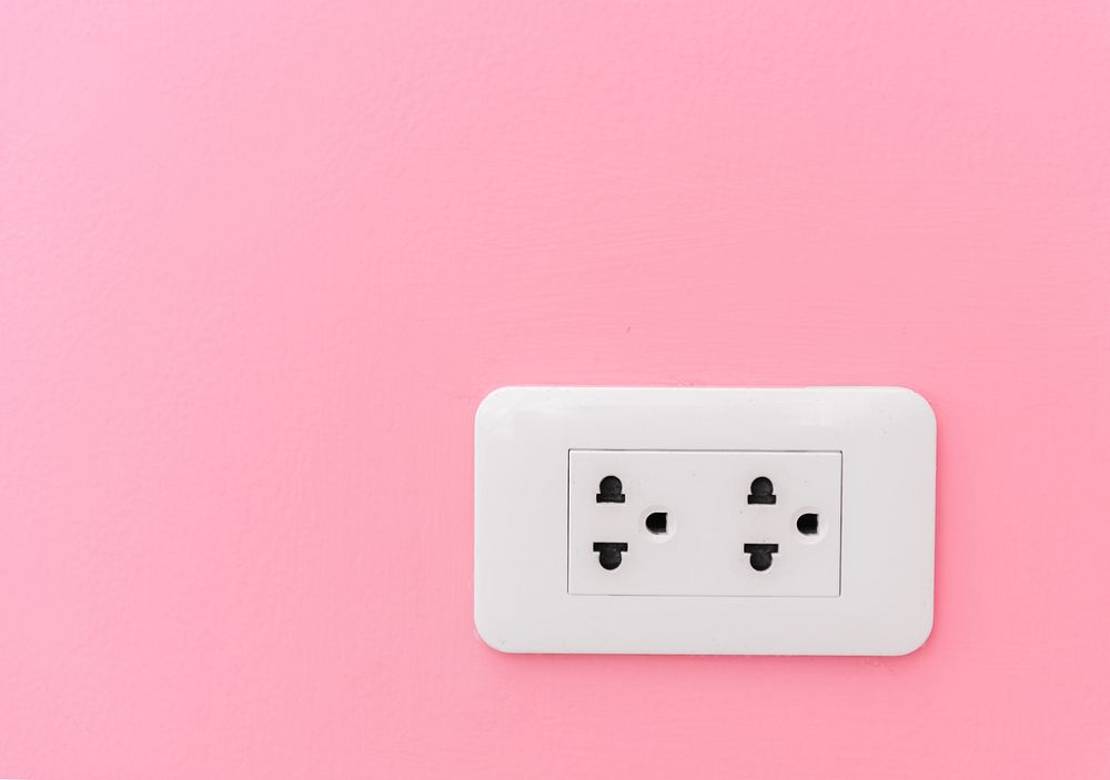 Electricity plug supply on pink wall