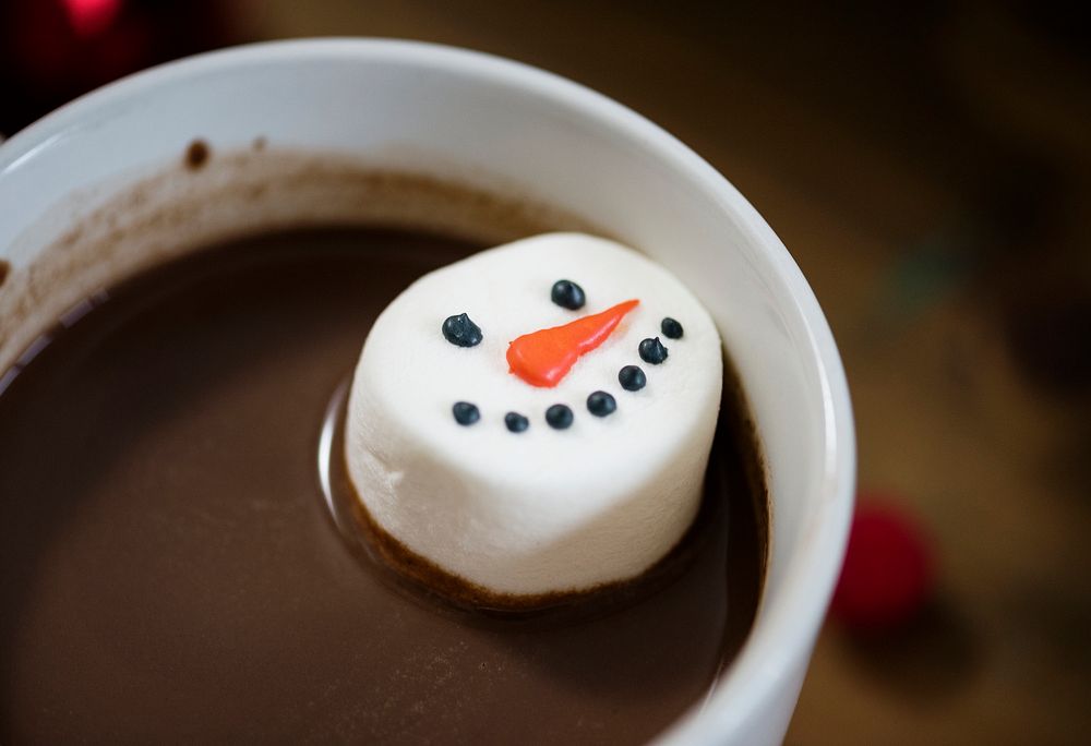 Snowman marshmallow dipped in hot chocolate