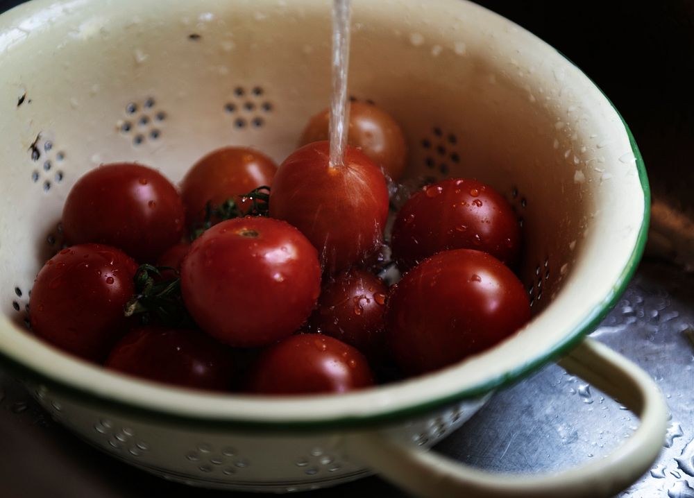 Rinsing fresh organic tomatoes in the sink