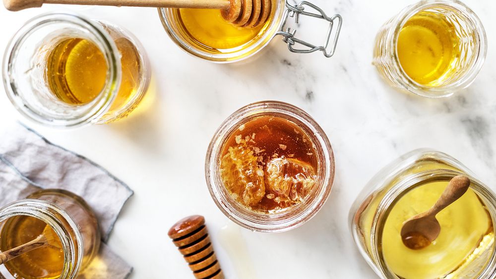 Food desktop wallpaper background, organic honey in a glass jar