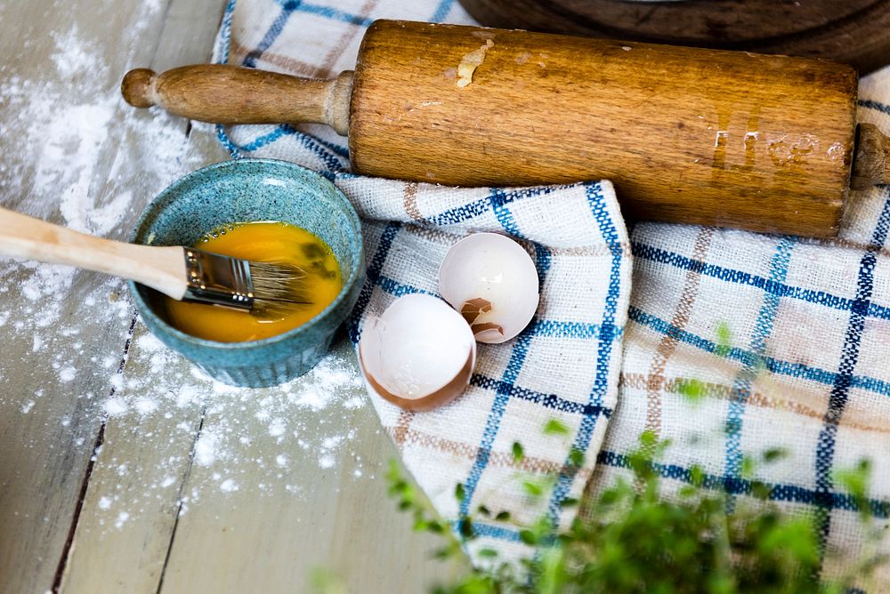Egg and a rolling pin on a wooden table