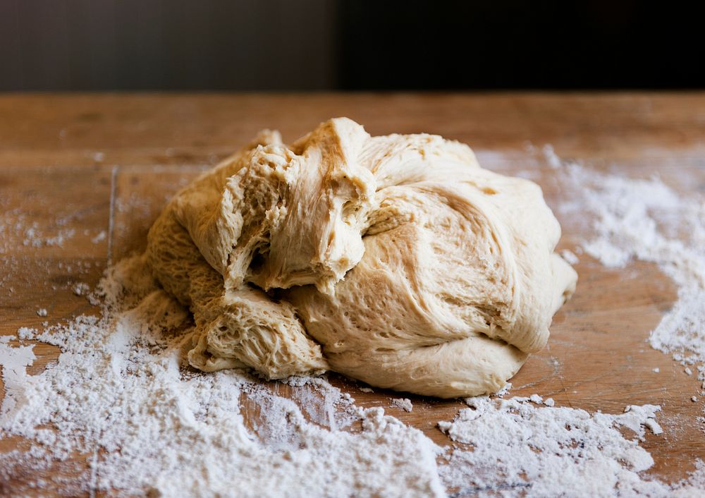 Dough on a wooden table with flour