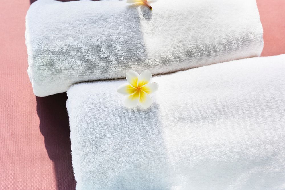 White towels decorated with plumeria flowers