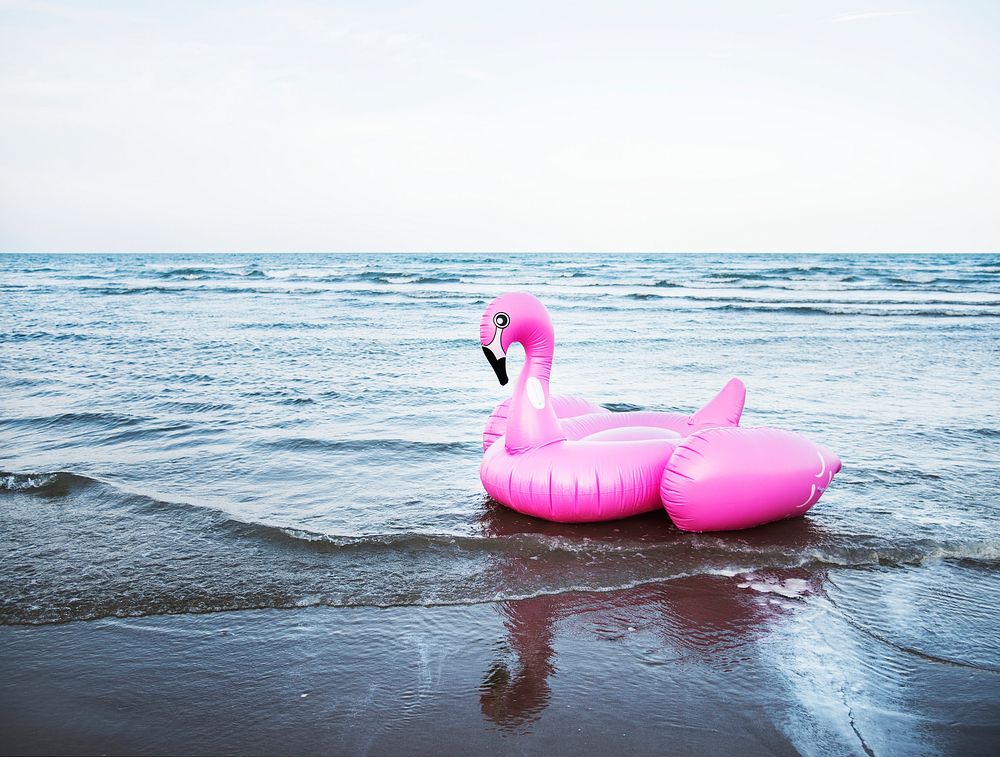 Inflatable pink flamingo tube on the beach