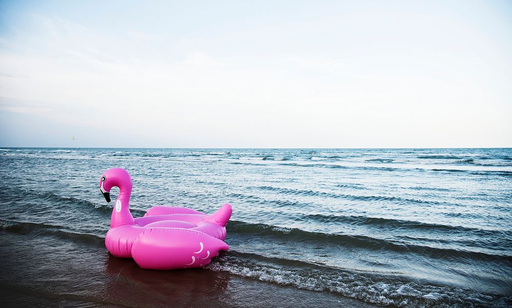 Inflatable pink flamingo tube on the beach
