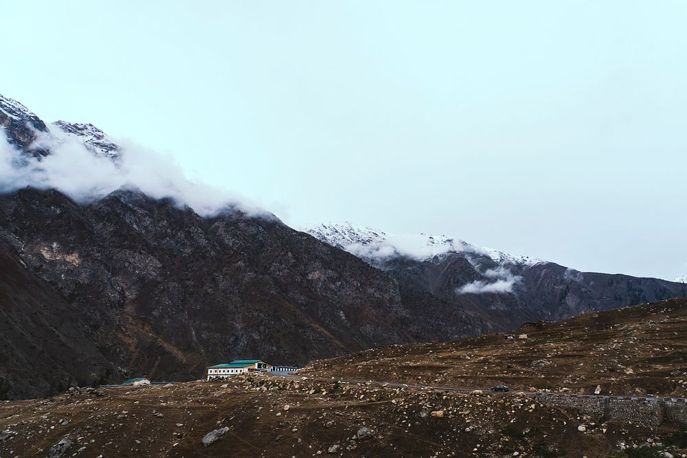 Solitary building by the mountains with a Pakistani flag