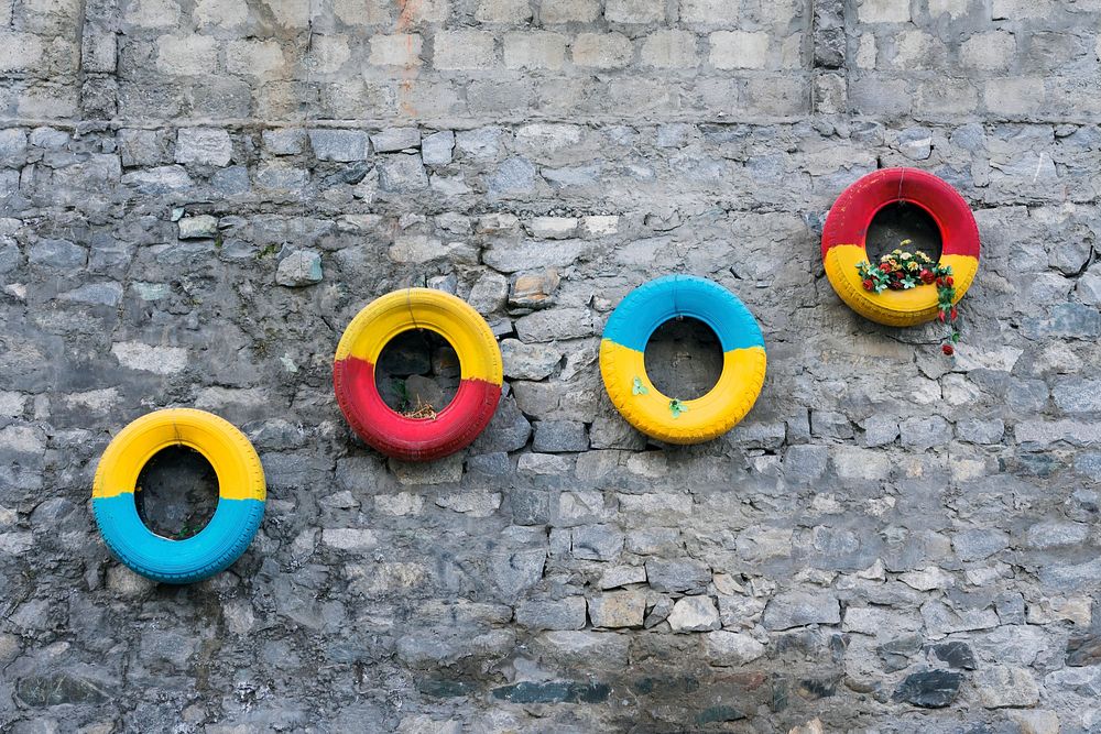 Colorful tires decorated on a stony wall