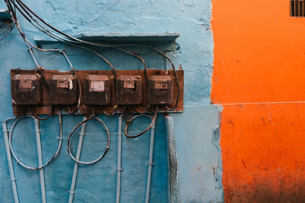 Old electricity meters on a fade blue wall
