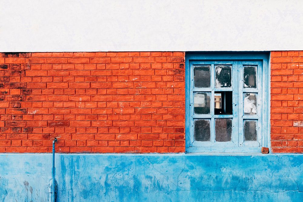Orange brick wall with a blue window in Varanasi, India