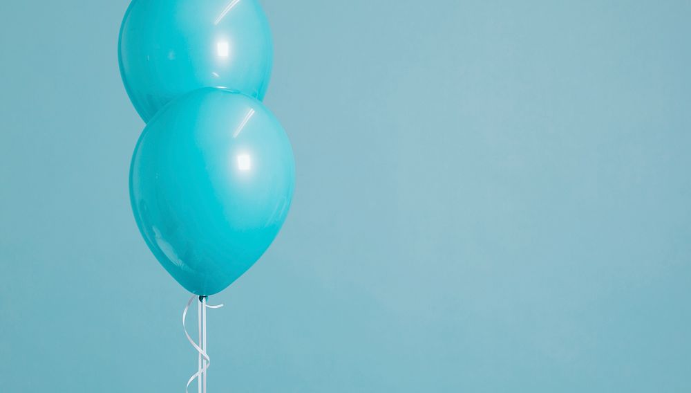 Two floating pastel blue balloons