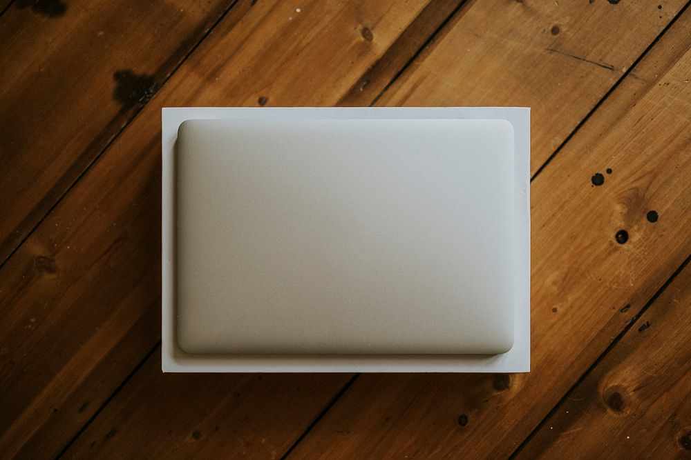 Aerial view of a white laptop on a wooden table