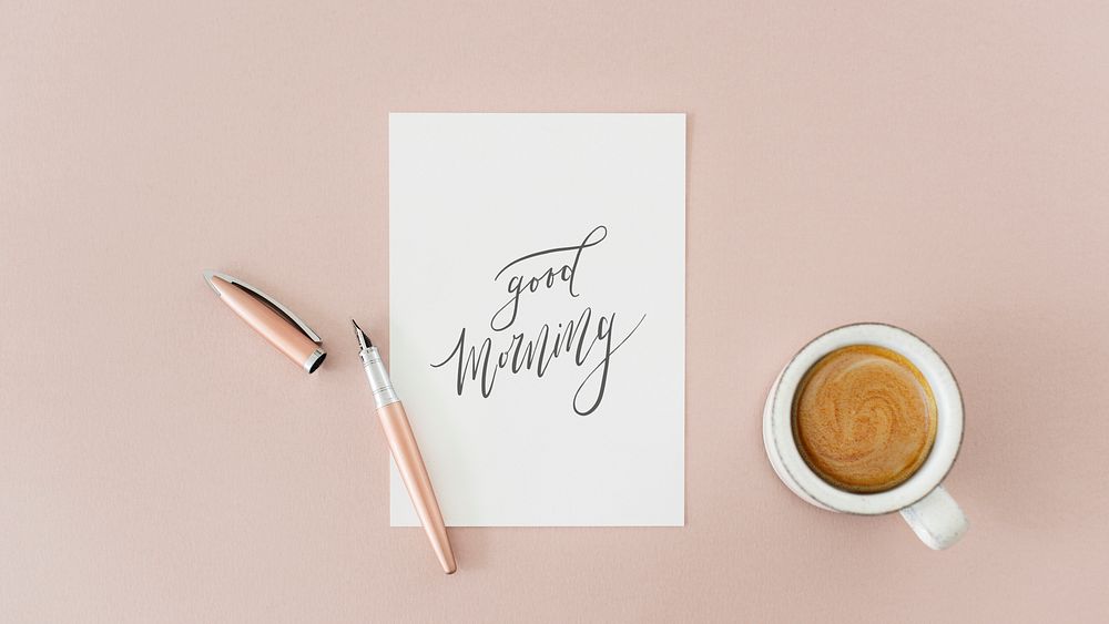 White paper mockup by a coffee cup on a pink table flatlay