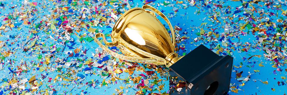 Gold trophy on a confetti background