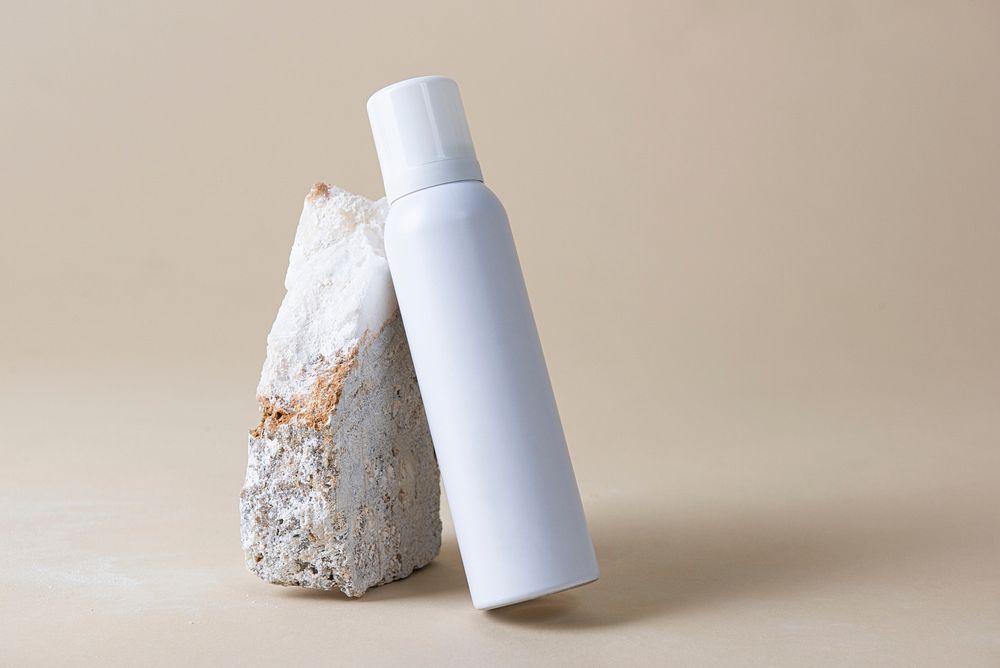 White spray bottle against a rock 