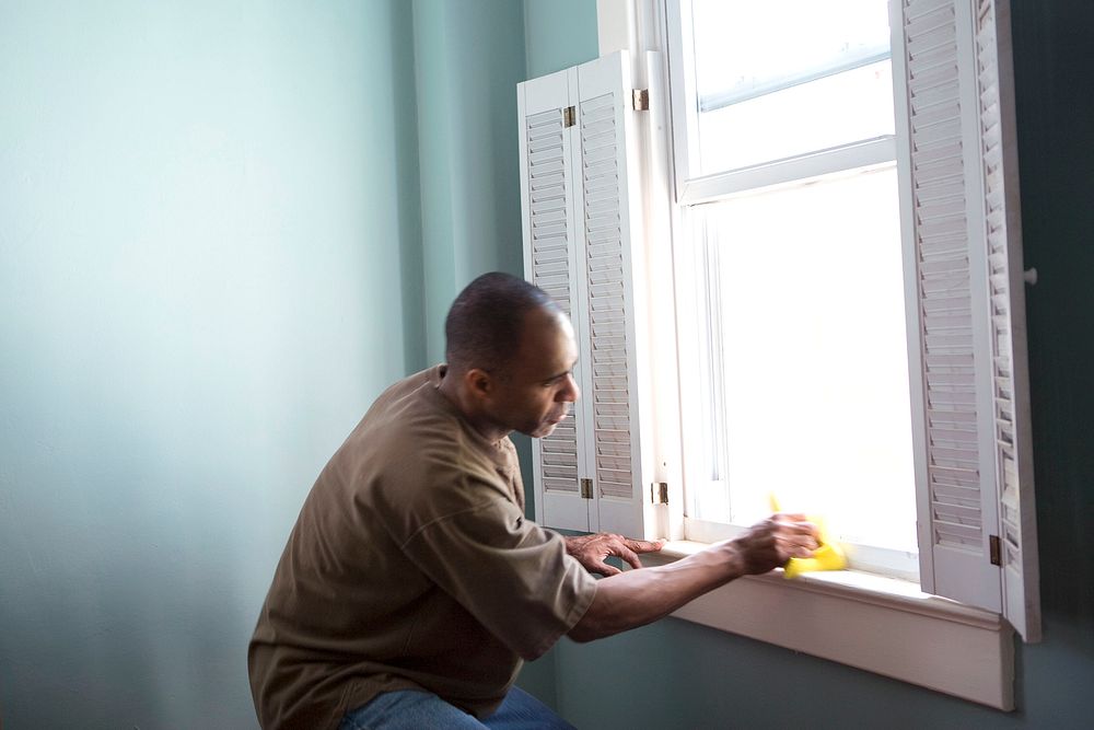 A man cleaning window. Original image sourced from US Government department: Public Health Image Library, Centers for…